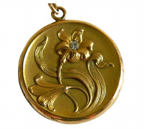 Gold pendant with a picture of a flower with a diamond. Gold pendant with a picture of a flower with a diamond.